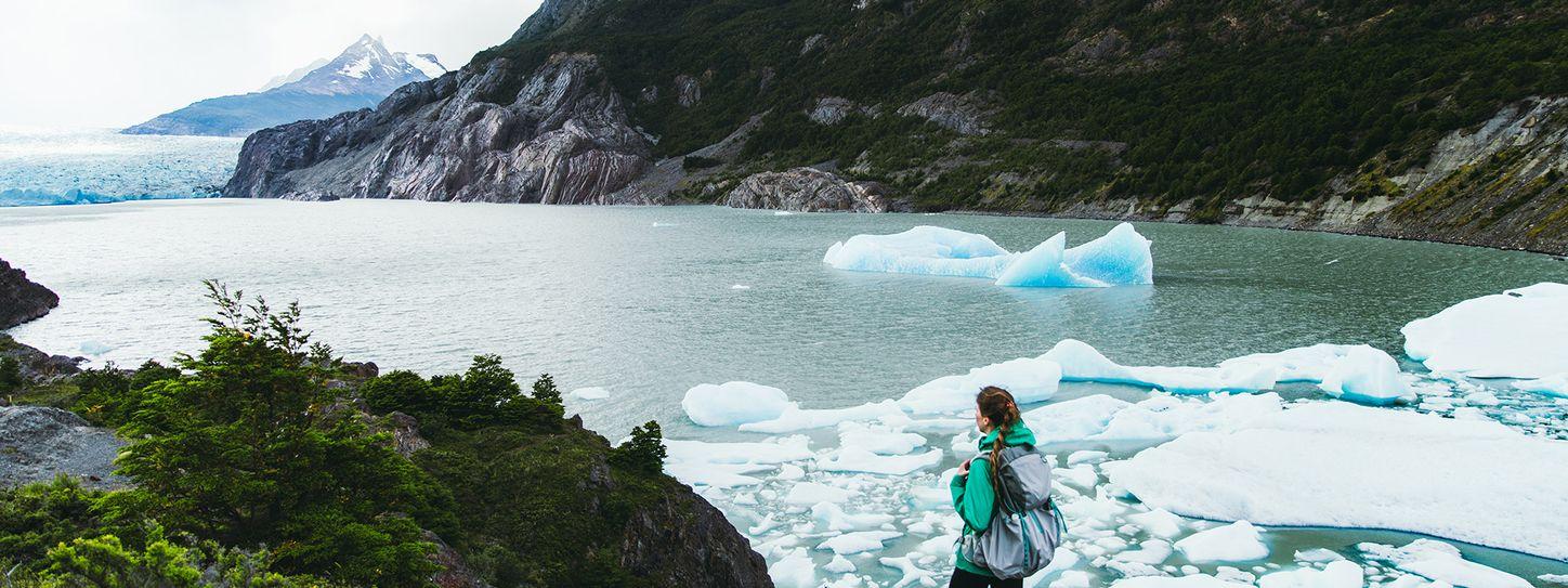 Kvinde står ved fjord med smeltende is